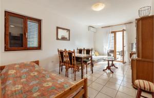 a bedroom with a table and chairs and a dining room at Beautiful Apartment In Herceg Novi With 1 Bedrooms, Wifi And Outdoor Swimming Pool in Herceg-Novi