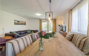 una sala de estar con una larga mesa de madera con flores. en Beautiful Home In Wemeldinge With Wifi, en Wemeldinge