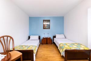 two beds in a room with blue walls at Apartment Petar in Poljica