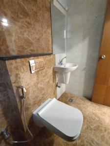 a bathroom with a sink and a toilet and a mirror at Hotel Zain Grande in Chennai