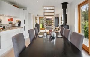 une cuisine et une salle à manger avec une table et des chaises noires dans l'établissement Gorgeous Home In Stubbekbing With Kitchen, à Stubbekøbing