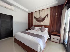 a bedroom with a large bed and a window at Grand Yuna Hotel Nusa Penida in Toyapakeh