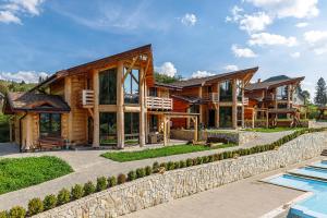 une maison en rondins avec une piscine et un complexe dans l'établissement Adel Resort, à Plavie