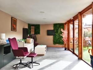 ein Wohnzimmer mit lila Stühlen und einer weißen Couch in der Unterkunft casa julian in Cistierna