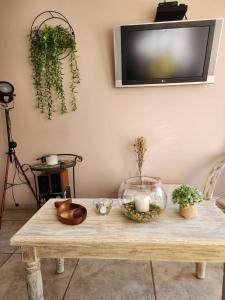 een houten tafel met kaarsen en een tv aan de muur bij Playa y Descanso Chic in Coquimbo