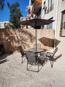 een tafel met twee stoelen en een parasol bij Playa y Descanso Chic in Coquimbo