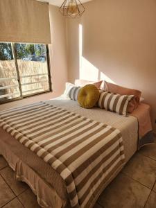 uma cama com duas almofadas num quarto em Playa y Descanso Chic em Coquimbo