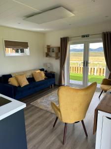 a living room with a blue couch and a window at Patie's Hill in Penicuik