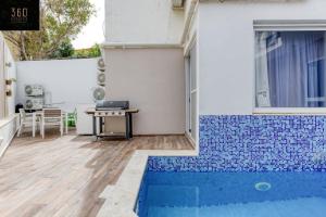 a house with a swimming pool and a table at A lovely 4BR home with private POOL & BBQ by 360 Estates in Is-Swieqi