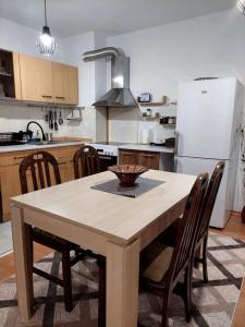 Il comprend une cuisine équipée d'une table avec des chaises et d'un réfrigérateur blanc. dans l'établissement Doris' 1 Bedroom Apartment, à Sofia