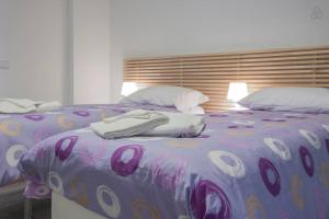 een bed met een paars dekbed en kussens bij B&B Sempione in Cosenza
