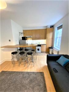 a living room with a couch and a kitchen at Smart 1 Bedroom Apartment in the City - Islington in London