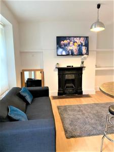 a living room with a couch and a flat screen tv at Smart 1 Bedroom Apartment in the City - Islington in London