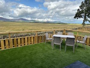 a patio with a table and chairs on the grass at Green Law - Dog Friendly in Penicuik