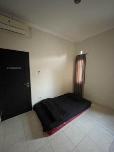 克羅柏坎的住宿－Puri Anggrek Homestay，卧室位于客房的角落,配有一张床