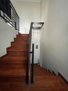 a staircase in a building with wooden floors and a metal railing at Puri Anggrek Homestay in Kerobokan