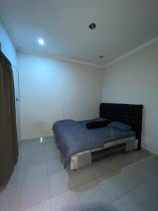 a bedroom with a bed in the corner of a room at Puri Anggrek Homestay in Kerobokan