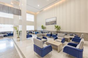 a waiting room with blue chairs and tables at فندق بلينسية Balensia Hotel in Al Madinah