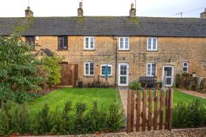 an old brick house with a garden in front of it at 2 Bedroom Charming & Luxury Malt Cottage, Garden, Netflix, Free Parking in Bourton on the Water