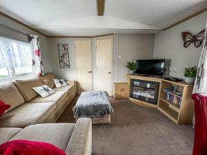 a living room with a couch and a tv at Superb 6 Berth Caravan With Decking At Seawick Holiday Park, Essex Ref 27009mv in Clacton-on-Sea