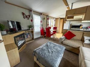 ein Wohnzimmer mit einem Sofa und einem Tisch mit Stühlen in der Unterkunft Superb 6 Berth Caravan With Decking At Seawick Holiday Park, Essex Ref 27009mv in Clacton-on-Sea