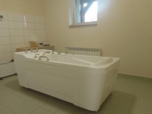 a white bathroom with a tub and a sink at Zajazd Tusinek Grzegorz Winiarek in Rozogi +50 photos