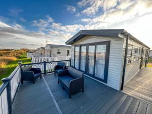 una gran terraza con sillas y una casa en Beautiful 6 Berth Caravan With Decking, Wifi And Field Views Ref 29029sv en Clacton-on-Sea