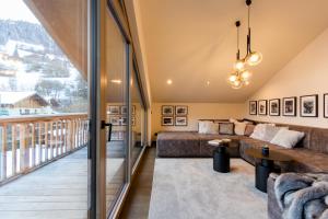 a living room with a couch and a balcony at Dorfchalet das Luxus-Wellness-Chalet im Skigebiet in Grossarl