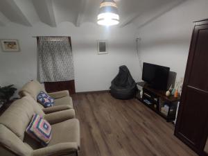 uma sala de estar com um sofá e uma televisão em CASA DALMA em Ballestar