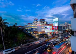 a busy city street with buildings and traffic at night at Hotel Stay Bella Kozhikode in Kozhikode