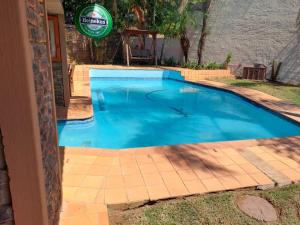 a swimming pool in a yard with a tile floor at SABLE INN B&B in Modimolle