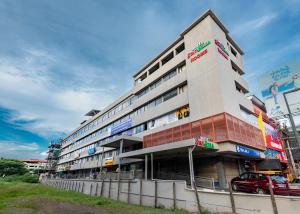 a building with a car parked in front of it at Hotel Stay Bella Kozhikode in Kozhikode