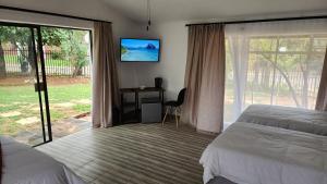 莫迪默勒SABLE INN B&B的一间卧室，配有一张床、一张书桌和一台电视