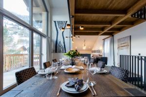 a dining room with a long wooden table and chairs at Dorfchalet das Luxus-Wellness-Chalet im Skigebiet in Grossarl