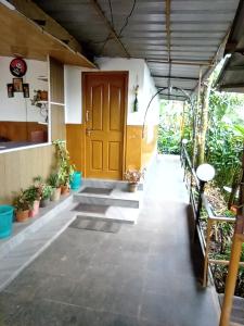 a hallway with a wooden door and some plants at Munnar home stay Teadrops plantation villa in Munnar