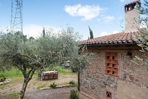 un edificio de piedra con una mesa y un árbol en Casa Collicello relax, en Camaiore