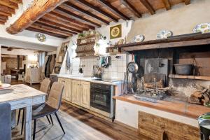 cocina con fogones y mesa con sillas en Casa Collicello relax, en Camaiore