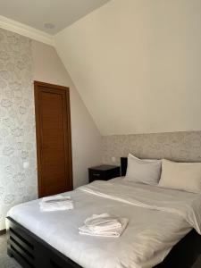 a bedroom with a bed with towels on it at 7 Rooms in Tbilisi City
