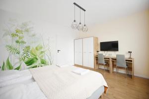 - une chambre avec un lit et un bureau avec une télévision dans l'établissement Victus Apartamenty, Apartament Rey, à Sopot