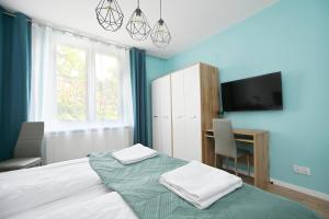 - une chambre avec un lit, un bureau et une télévision dans l'établissement Victus Apartamenty, Apartament Rey, à Sopot