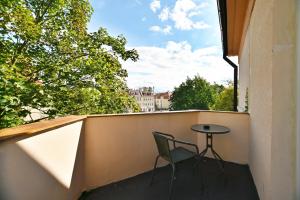 une chaise assise sur un balcon avec une table dans l'établissement Victus Apartamenty, Apartament Rey, à Sopot