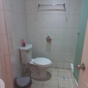 y baño con aseo blanco y ducha. en Hotel Arauco Ovalle, en Ovalle