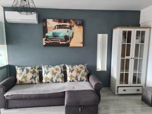 un salon avec un canapé et une photo de voiture dans l'établissement Mall Luxury VI Apartment, à Bacău