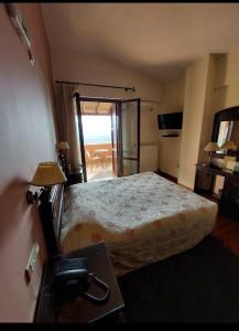 Schlafzimmer mit einem Bett und einem Schreibtisch mit einem Telefon in der Unterkunft Vytina Mountain View Hotel in Vitina