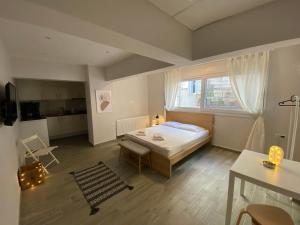 a bedroom with a bed and a table and a window at Design downtown suite (K2) in Larisa