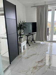 a living room with a television and a desk at Hamdanes Apartment in Sundern