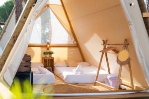 a room with two beds in a tent at Kampaoh Lago de Arcos in Arcos de la Frontera