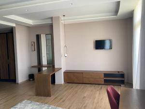 sala de estar con TV en la pared en Bolv Hotel, en Durrës