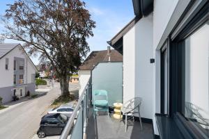 a balcony with chairs and a view of a street at ANYTIME - Apartments in Langenargen in Langenargen