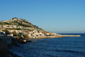a village on a hill next to the ocean at Le cabanon de Manon in Marseille